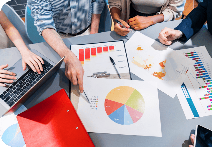 デスクの上に資料を並べて会議している写真